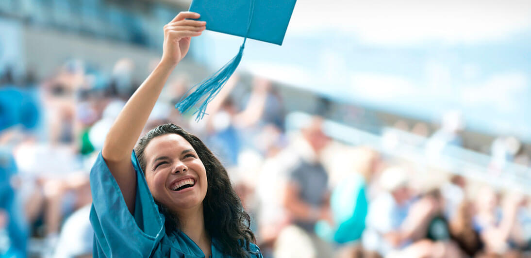 A graduate throwing a mortarboard into the air